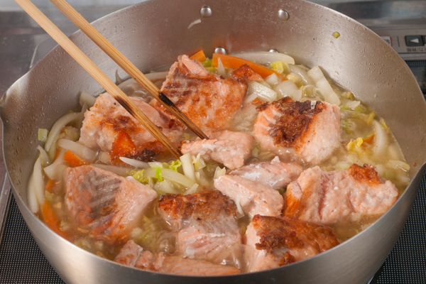 鍋をサッと拭いて油を熱し、1の玉ねぎ、ニンジン、白菜を入れてサッと炒め、全体に少ししんなりしてきたら1のスープを加える。沸騰したら1の秋鮭を加え、弱火で8分程煮る。