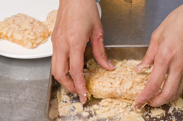 小麦粉、卵、スライスアーモンドをミックスしたパン粉の順にタラにつける。