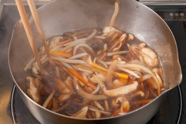 千切りにしたしいたけ、にんじん、玉ねぎともやしを鍋に入れ、Aの調味料を入れて加熱する。