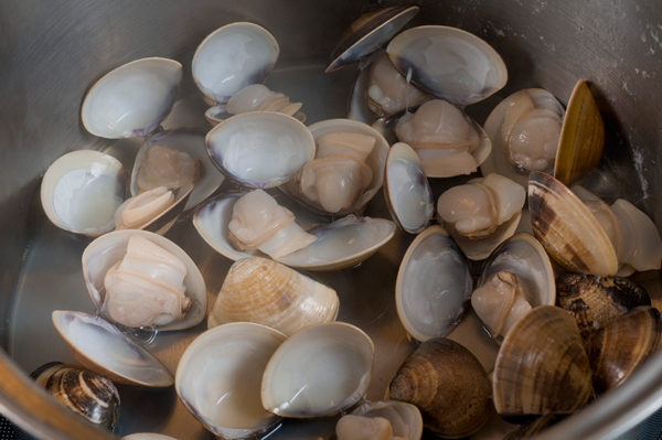 塩水3％（海水程度）を作り、そこにハマグリを入れ、数時間漬けて砂を吐かせる。砂抜きが終わったら貝殻同士をこすり合わせ、水でよく洗って鍋に入れ、ワインを加えフタをして強火にかける。3分程蒸し煮にして殻を開け、身を取り出し、蒸し汁はこしておく。ベーコンは千切りに、玉ねぎはみじん切り、エリンギはスライスし、キャベツは3cm角に切っておく。