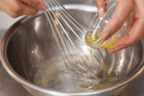 ドレッシングの材料（みじん切りにした玉ねぎ、酢、オリーブオイル、塩、コショウ）を合わせる。