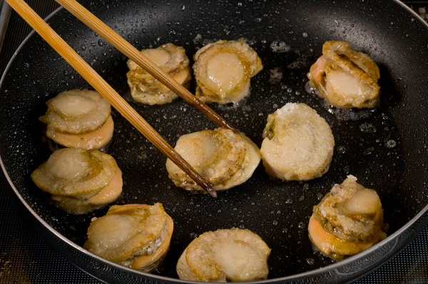 帆立に塩、コショウをふり、片栗粉をまぶす。フライパンに油を熱し、帆立の両面をサッと焼いて、一旦取り出す。白菜とチンゲン菜は葉と芯に分け、それぞれ芯の部分は短冊切りに、葉の部分は食べやすい大きさに切る。ベーコンは1cm位の薄切り、ショウガは千切りにする。
