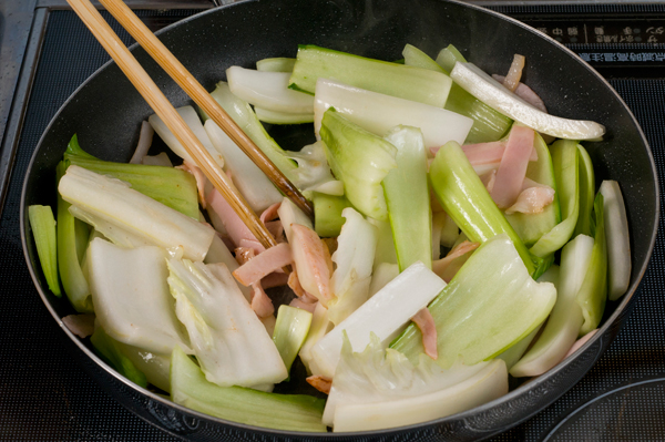 フライパンに1のベーコン、ショウガ、白菜（芯）、チンゲン菜（芯）の順に入れて炒める。