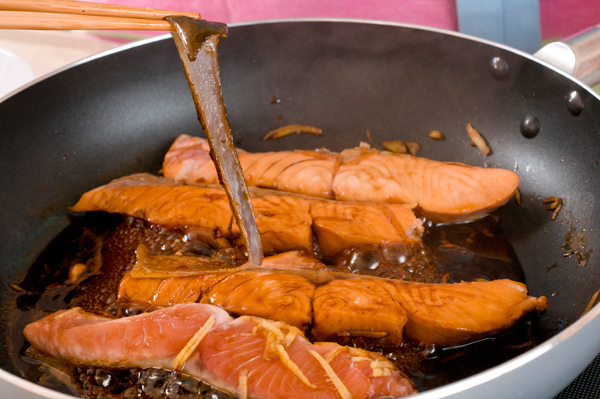 フライパンに生鮭を並べ入れ、千切りにしたショウガを散らしてめんつゆの素を回し掛けて火にかけ、煮る。