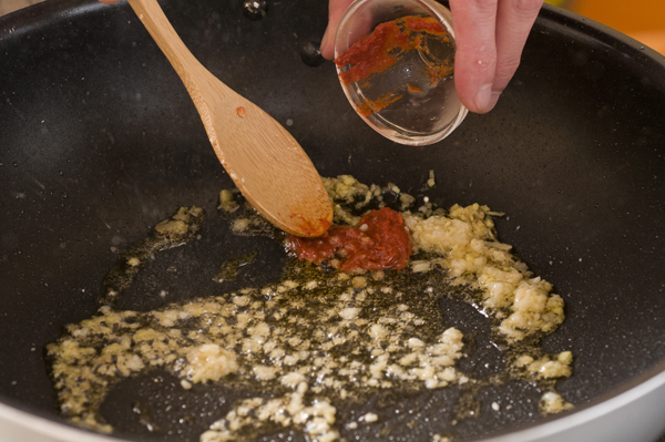 フライパンにゴマ油を熱してニンニクのみじん切りとショウガのみじん切りを炒め、香りが立ってきたら豆板醤を加え馴染むまで炒める。