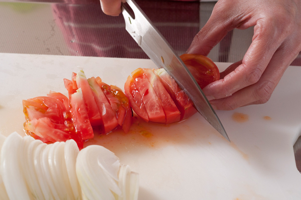 玉ねぎとトマトをそれぞれ、縦半分から縦薄切りにする。
