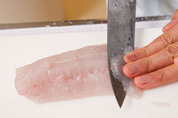 スズキは皮付きの場合は皮を剥ぎ、薄く削ぎ切りにする。