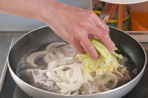 フライパンに水と白ワインを沸かして1（皮側を上）を並べ入れ、その上に2の野菜類を乗せて洋風スープの素を振り、強火でフタをして5分程度煮る。塩、コショウで味を調えて器に盛る。